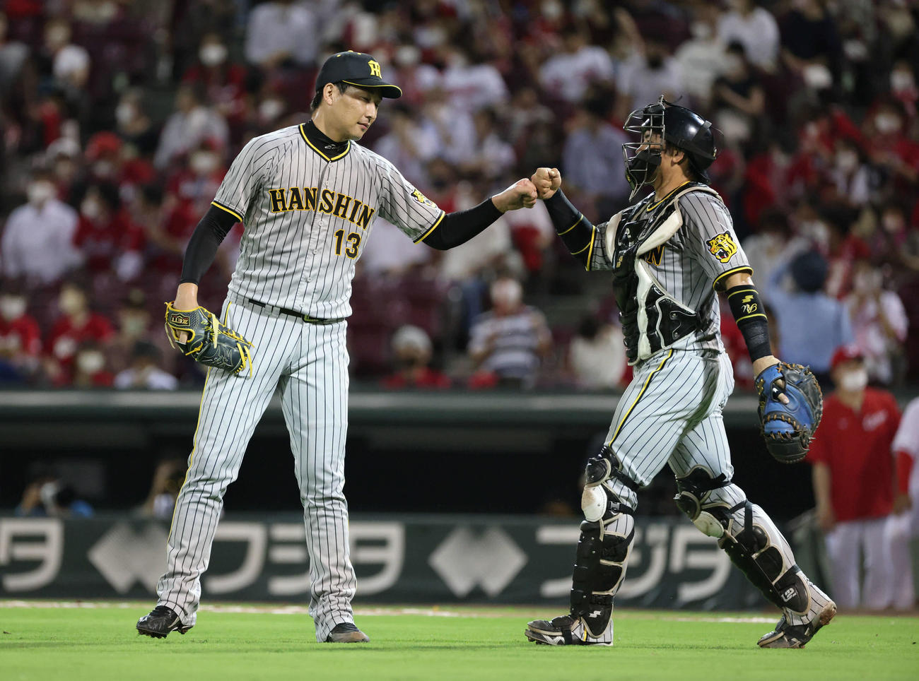 広島対阪神　広島に勝利しタッチを交わす抑えの岩崎（左）と梅野（撮影・加藤孝規）