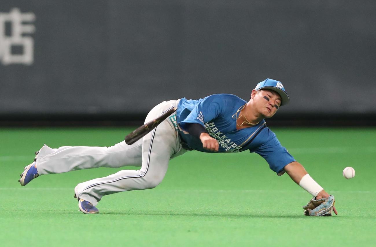 7月23日、日本ハム対ロッテ　打球に飛びつく日本ハム佐藤に折れたバットが直撃する