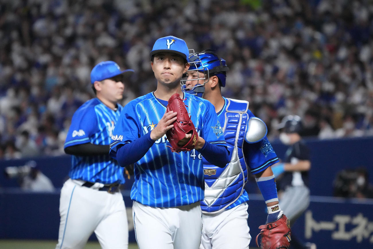 中日対DeNA 7回終了、グラブを叩きながらベンチへ戻るDeNA2番手の京山（中央）（撮影・森本幸一）