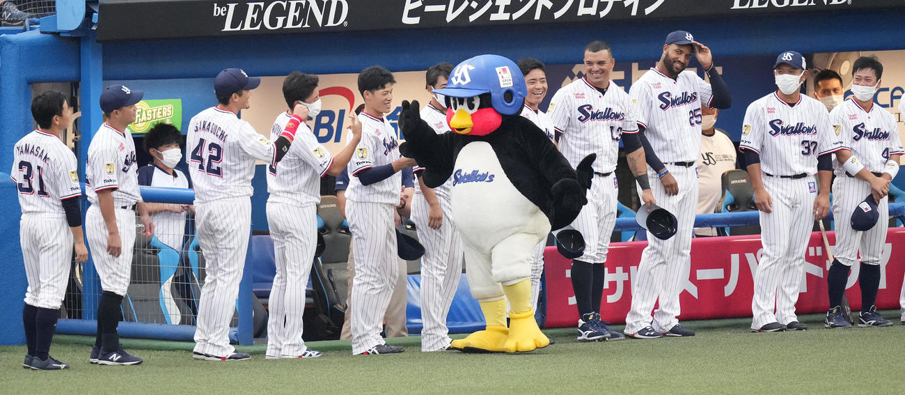 試合前、主催2000試合出場の表彰を終え、ナインとタッチを交わすつば九郎（撮影・鈴木みどり）