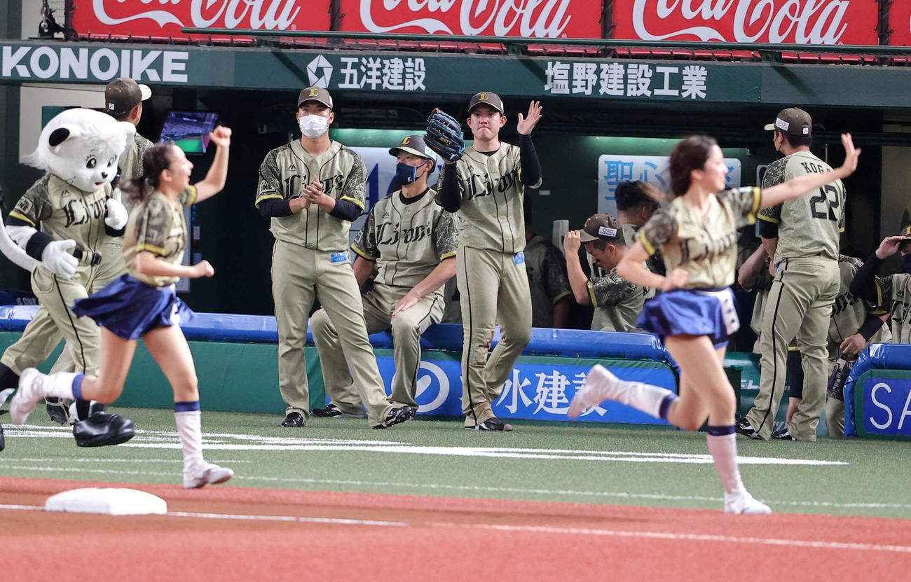 西武対ロッテ　7回表ロッテ2死一塁、井上を二塁飛に仕留めた与座（中央）は、マスコットガールの奥で拍手（撮影・浅見桂子）