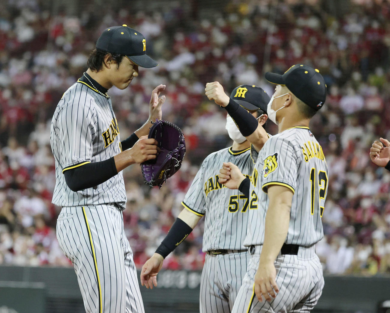 7回裏広島1死一、二塁で降板する藤浪（左）は坂本、長坂とハイタッチ（撮影・加藤孝規）