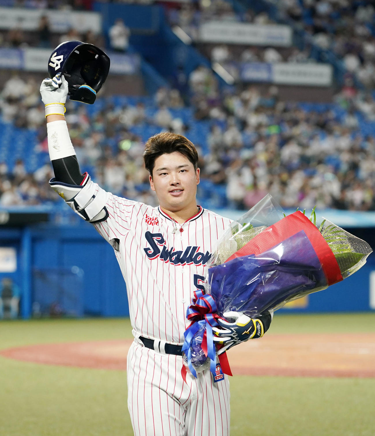 3回裏ヤクルト1死一塁、プロ野球新記録の5打席連続となる左中間への2点本塁打を放ち、花束を手に声援に応える村上（2022年8月2日撮影）