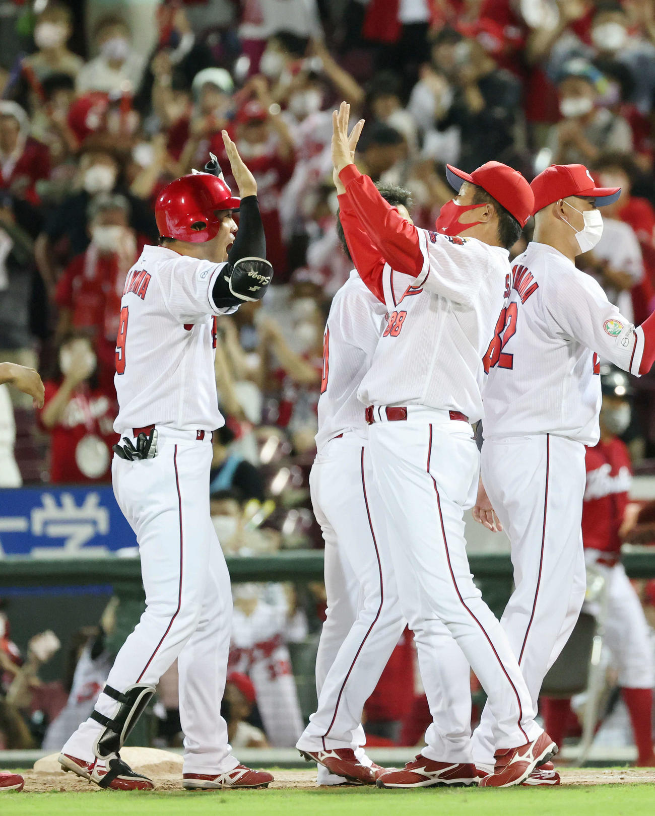 広島対阪神　9回裏広島1死一塁、サヨナラの右適時打を放った秋山（左）は佐々岡監督とハイタッチ（撮影・加藤孝規）