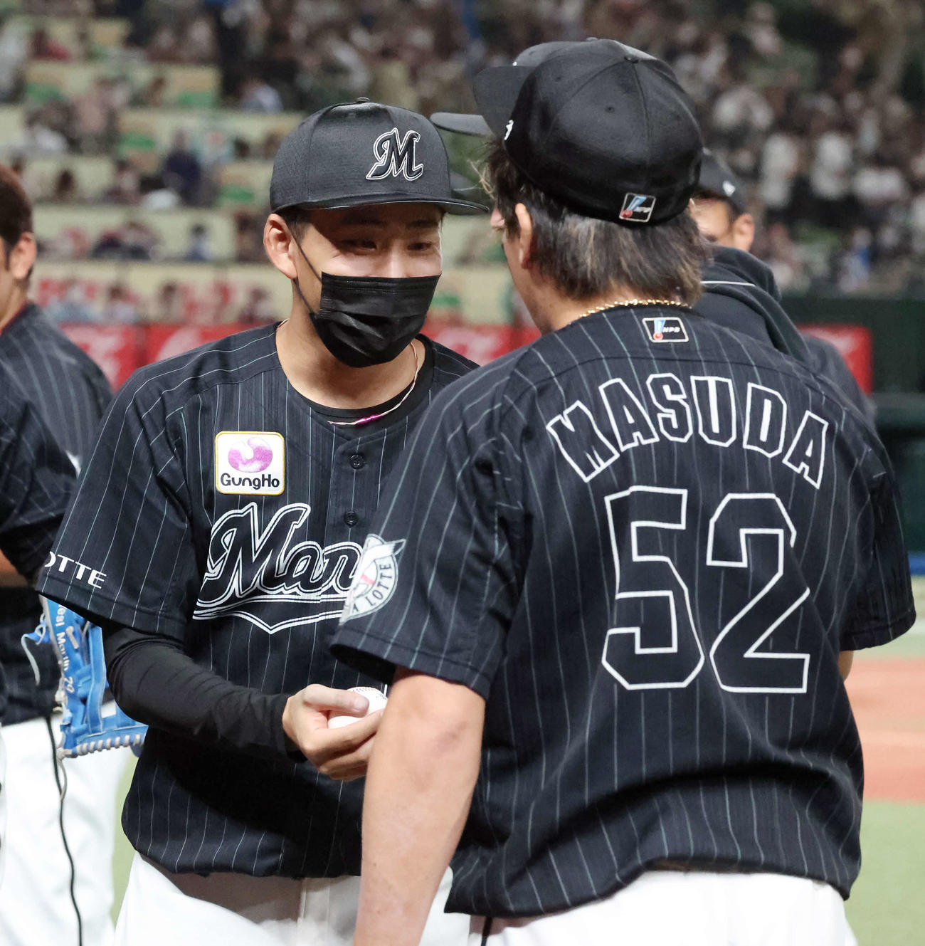 西武対ロッテ　9回を締めた益田（手前）からウイニングボールをもらった小島（撮影・丹羽敏通）