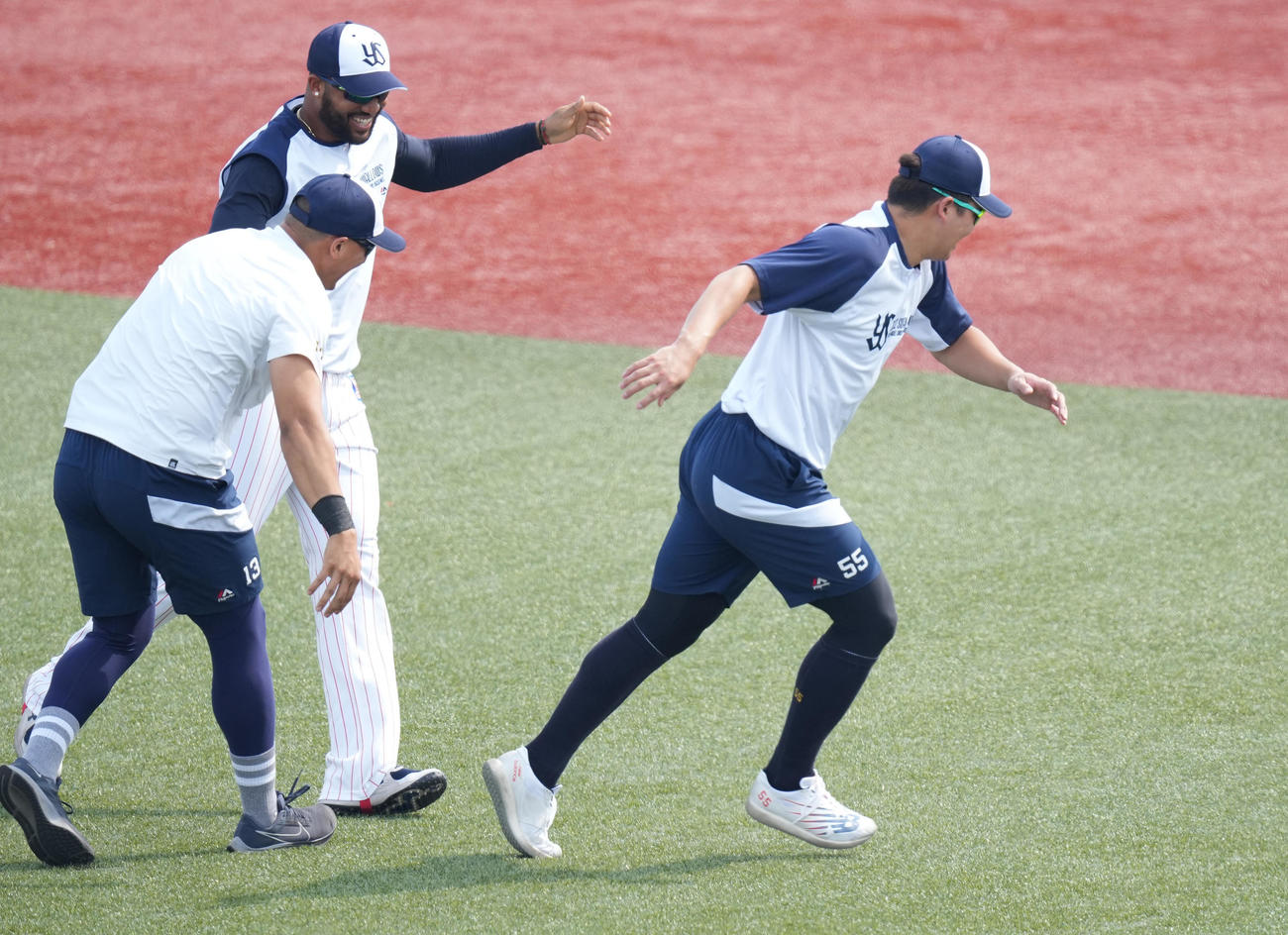 ヤクルト対巨人　1軍の練習に復帰したヤクルト村上（右）は歓迎するサンタナ（左奥）、オスナから逃げる（撮影・鈴木みどり）