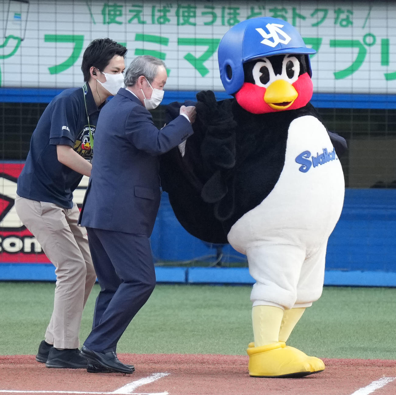 主催2000試合出場の表彰で、若松勉氏から名球会ジャケットを着せてもらうつば九郎（撮影・鈴木みどり）
