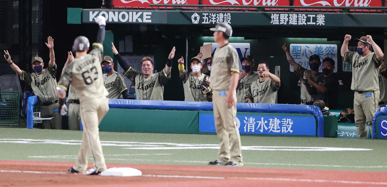 西武対ロッテ　4回裏西武2死一塁、長谷川（手前）が左越え同点適時三塁打を放ち、盛り上がる山川（中央）ら西武ベンチ（撮影・浅見桂子）