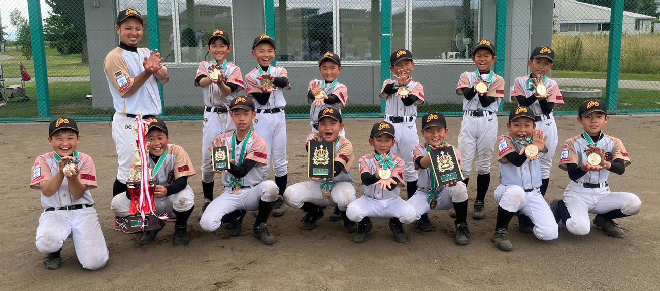 優勝メダルを首にかけポーズを決める釧路ゴールデンモンキーズBBCの選手たち