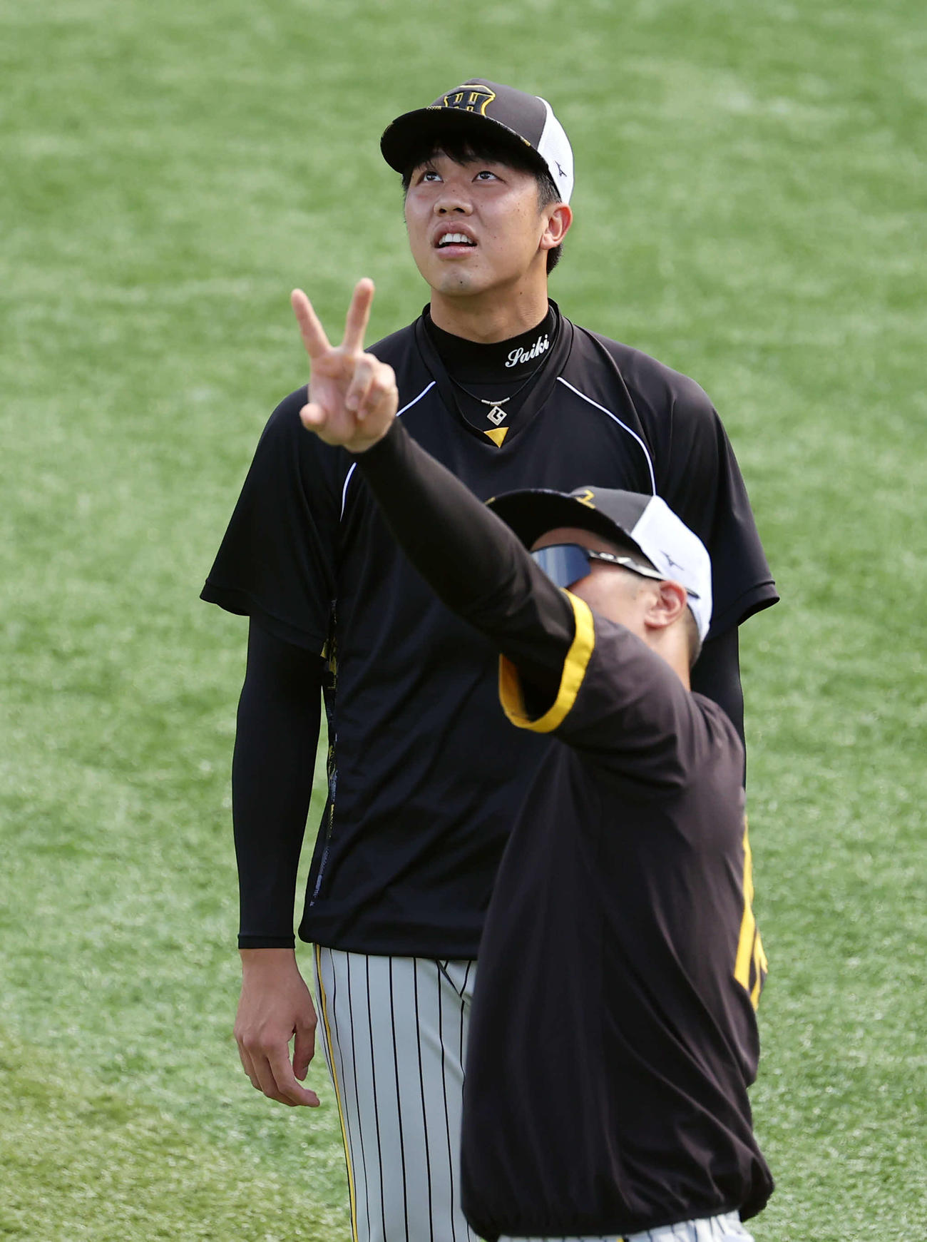 DeNA対阪神　ウオームアップ中、坂本（手前）と何かを見つめる才木（撮影・浅見桂子）