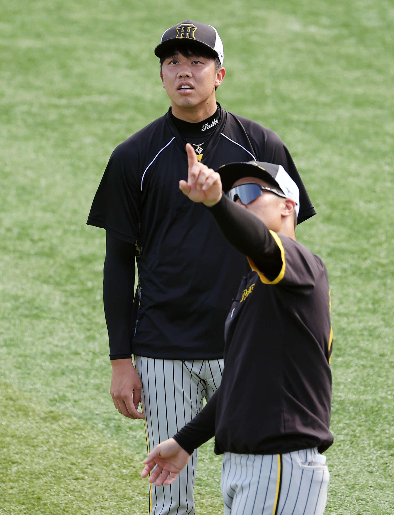 DeNA対阪神　ウオームアップ中、坂本（手前）と何かを見つめる才木（撮影・浅見桂子）
