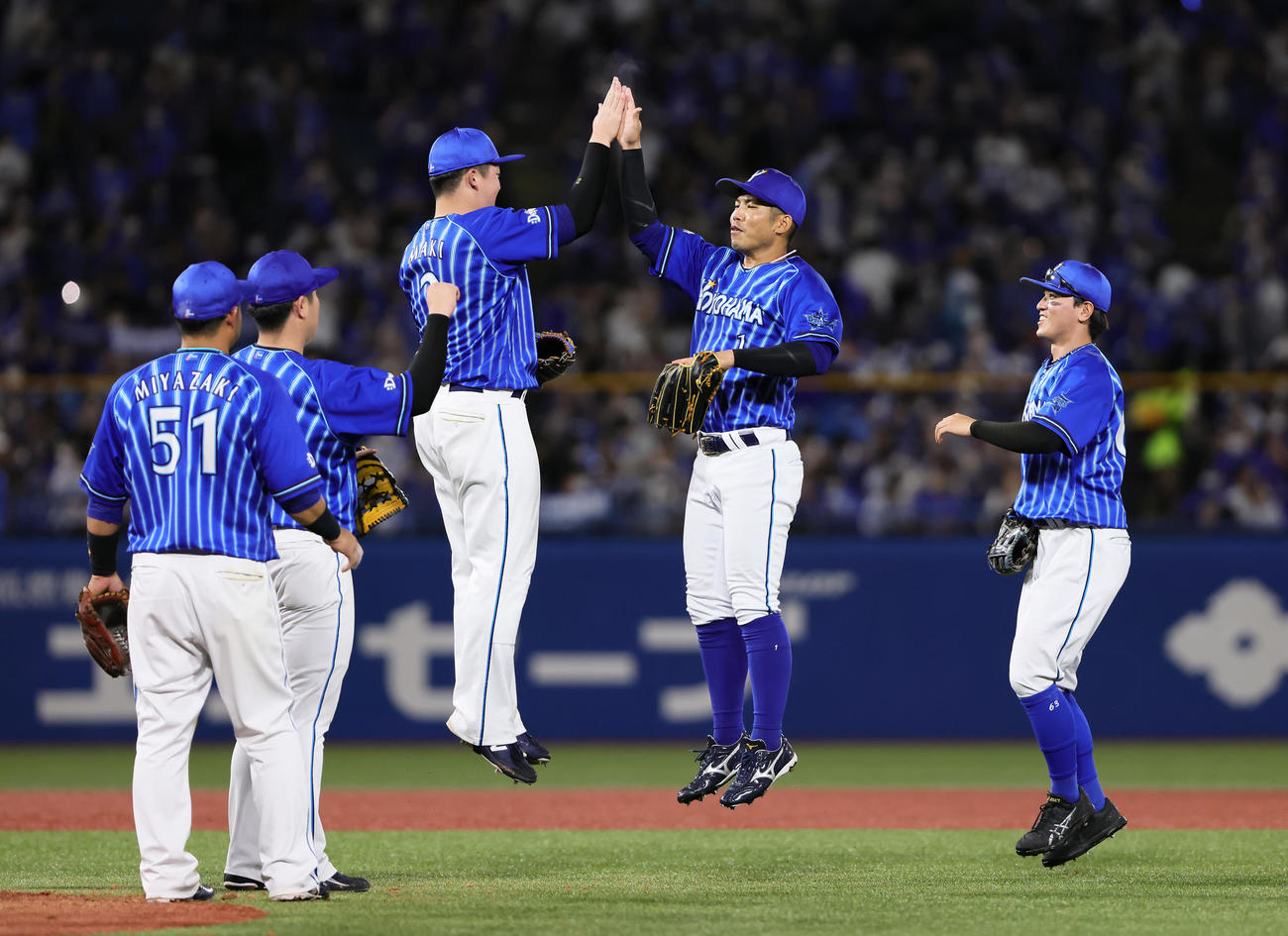 ヤクルト対DeNA勝利し、ジャンプでタッチを交わすDeNA牧（中央左）と桑原（同右）（撮影・足立雅史）
