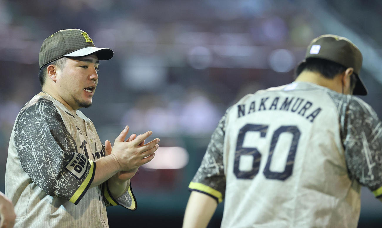楽天対西武　楽天に勝利し通算450号本塁打と1000得点を同時に達成した西武中村（右）に拍手を送る山川（撮影・垰建太）