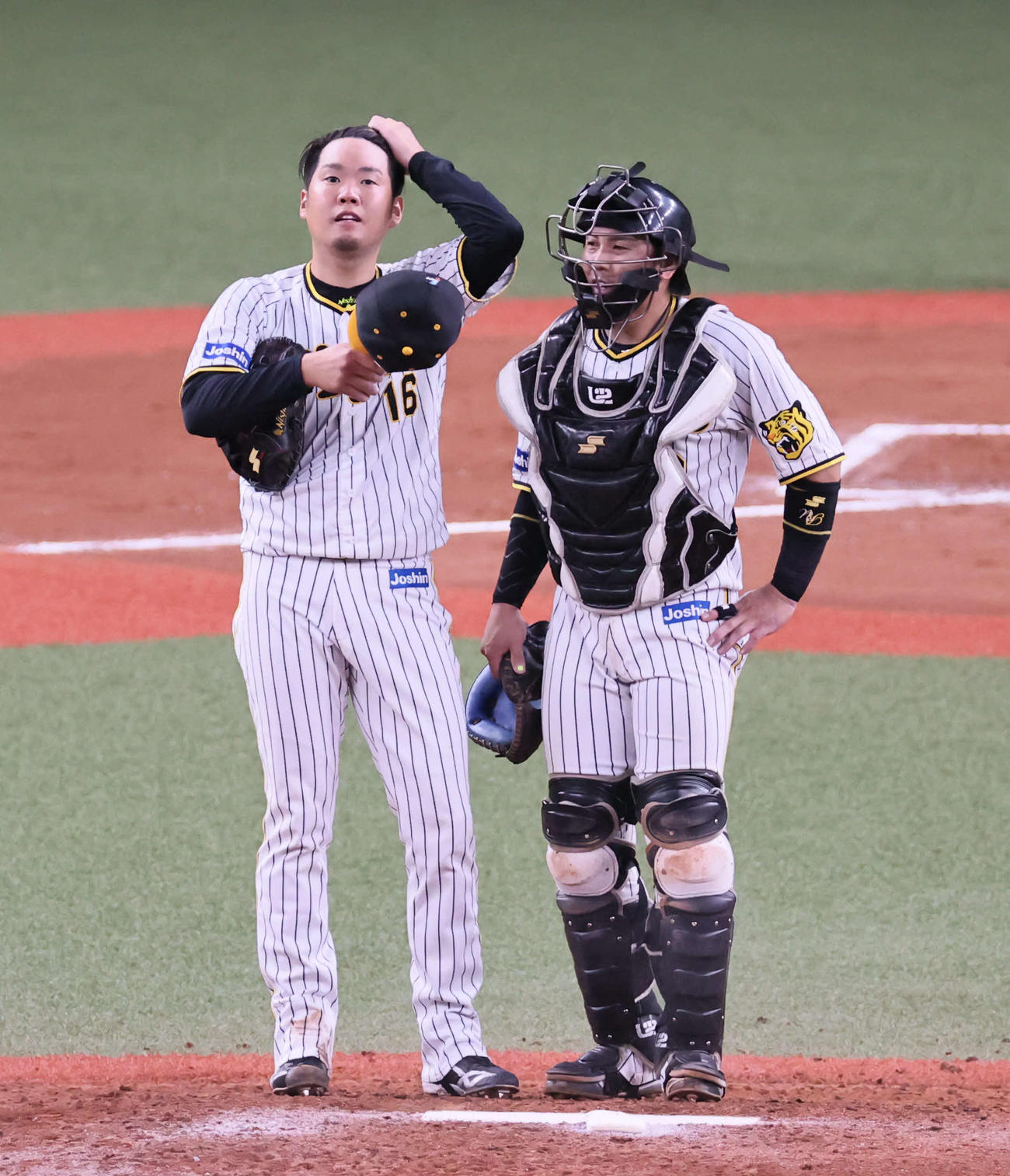 阪神対中日　7回表中日2死一、二塁、西勇（左）は梅野と話し合う（撮影・宮崎幸一）
