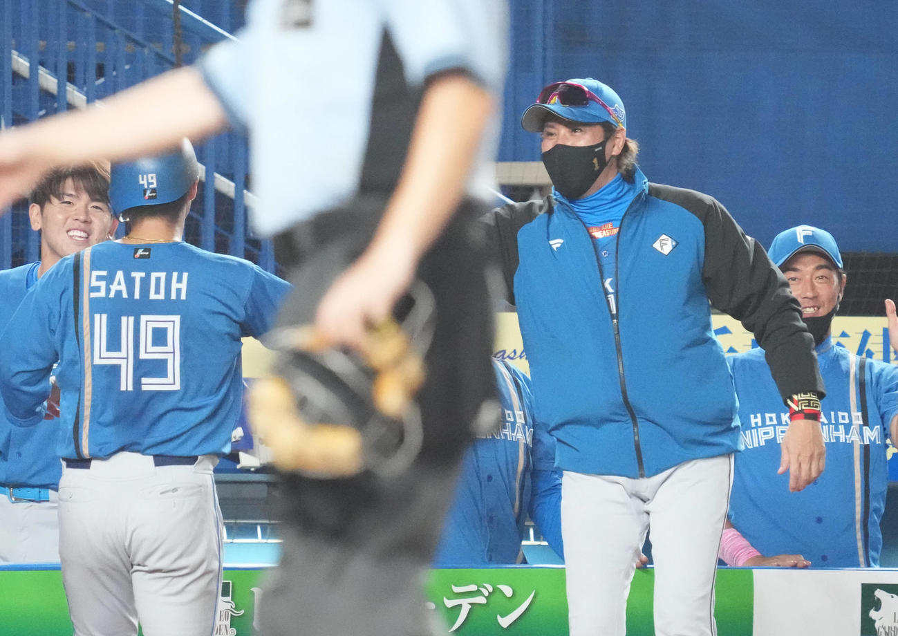 ロッテ対日本ハム　9回表日本ハム2死二、三塁、万波の左前同点適時打で生還した佐藤（左）を祝福する新庄監督（撮影・小沢裕）