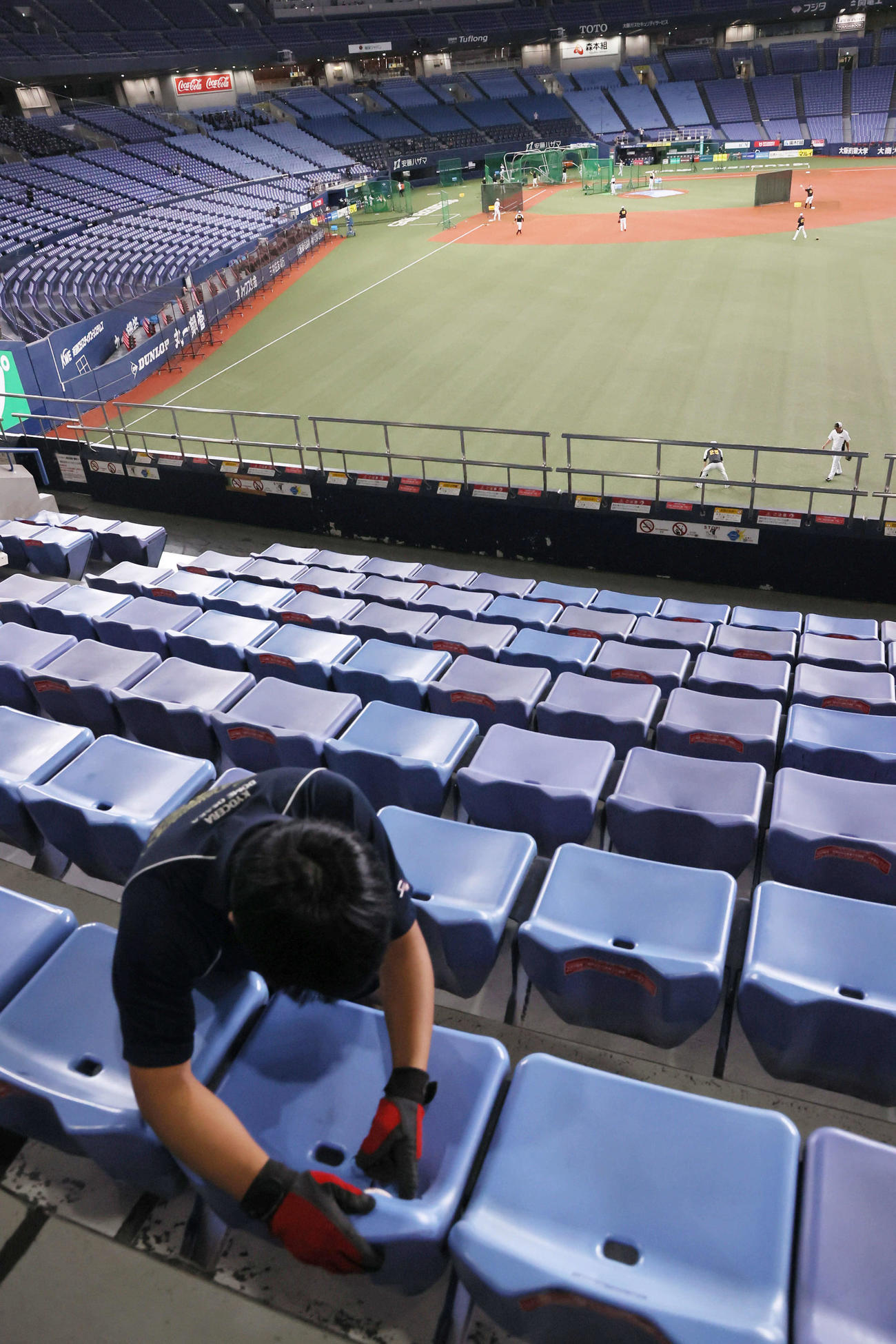阪神対中日　試合前練習で佐藤輝の打球がめり込んだ右翼席の座席からボールを外そうとするスタッフ（撮影・宮崎幸一）