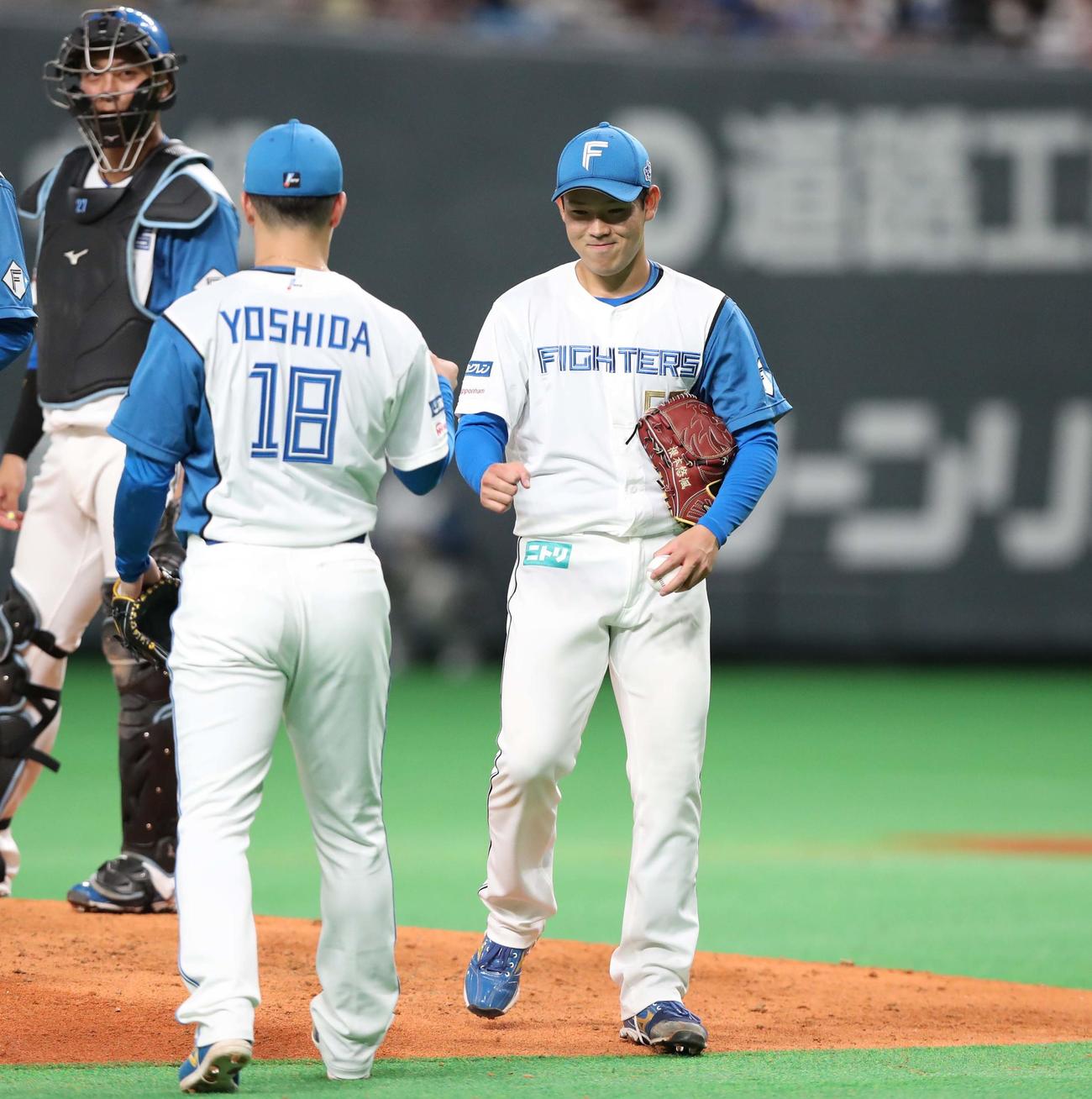 日本ハム対楽天　8回表、笑顔で吉田と交代する根本（撮影・黒川智章）