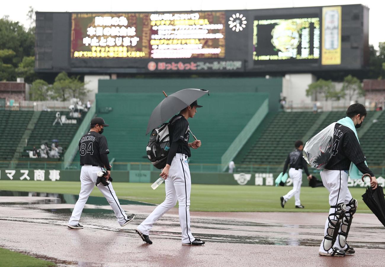 オリックス対ロッテ　突然の大雨で中止となり、水たまりの残るグラウンドを引き揚げる佐々木朗（撮影・上田博志）