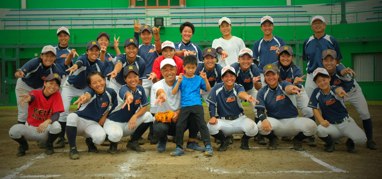 野球教室を終え、平成国際大女子硬式野球部の選手たちと笑顔で写真撮影する宮本慎也氏（前列中央）