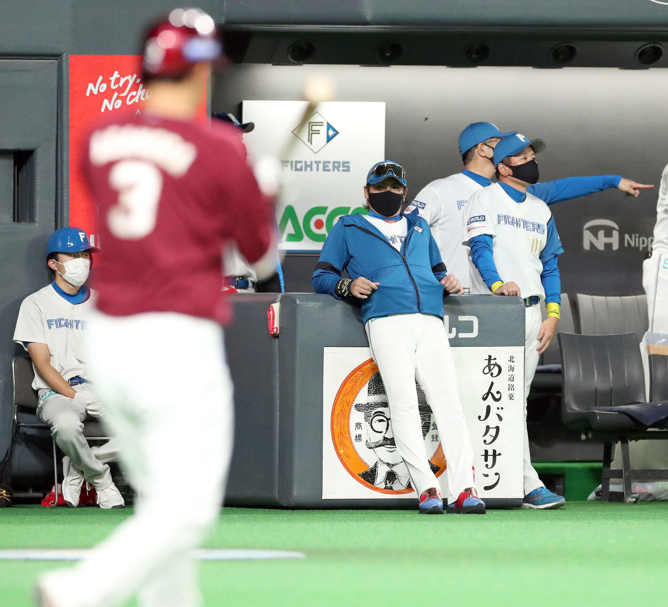 日本ハム対楽天　ベンチに寄りかかりながら浅村（左手前）を見つめる新庄監督（撮影・佐藤翔太）