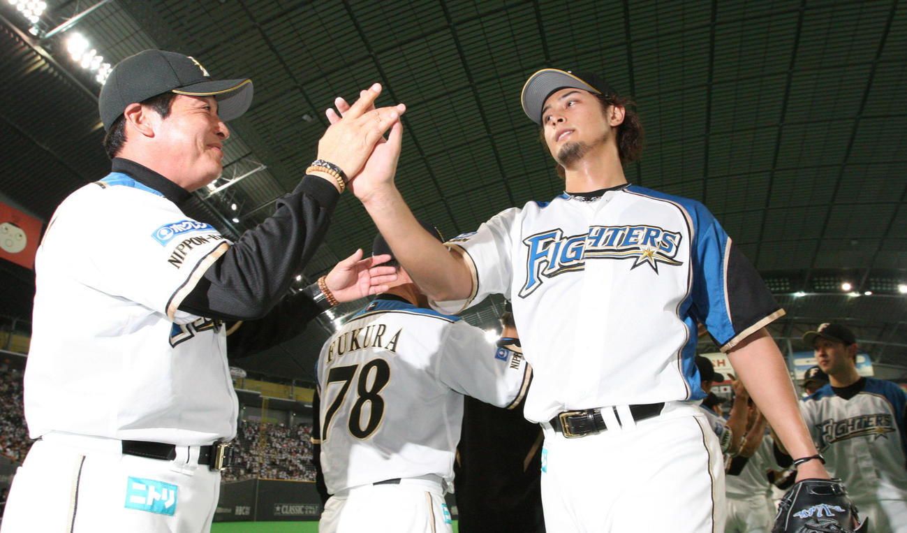 完封勝利を飾ったダルビッシュ（右）は梨田監督の出迎えを受ける