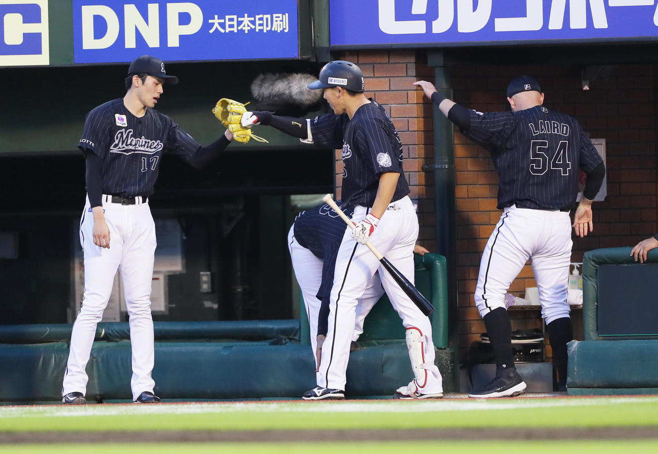 楽天対ロッテ　2回表ロッテ2死、同点本塁打の安田（中央）とタッチを交わす佐々木朗（左）（撮影・足立雅史）