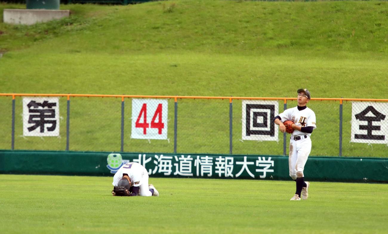 橿原八木対浦河第二・様似　延長8回タイブレーク橿原八木2死満塁、浦河第二・様似の和田（左）が打球を捕球しかけて落球。サヨナラ負けとなり地面に顔を伏せ悔しがる（撮影・永野高輔）