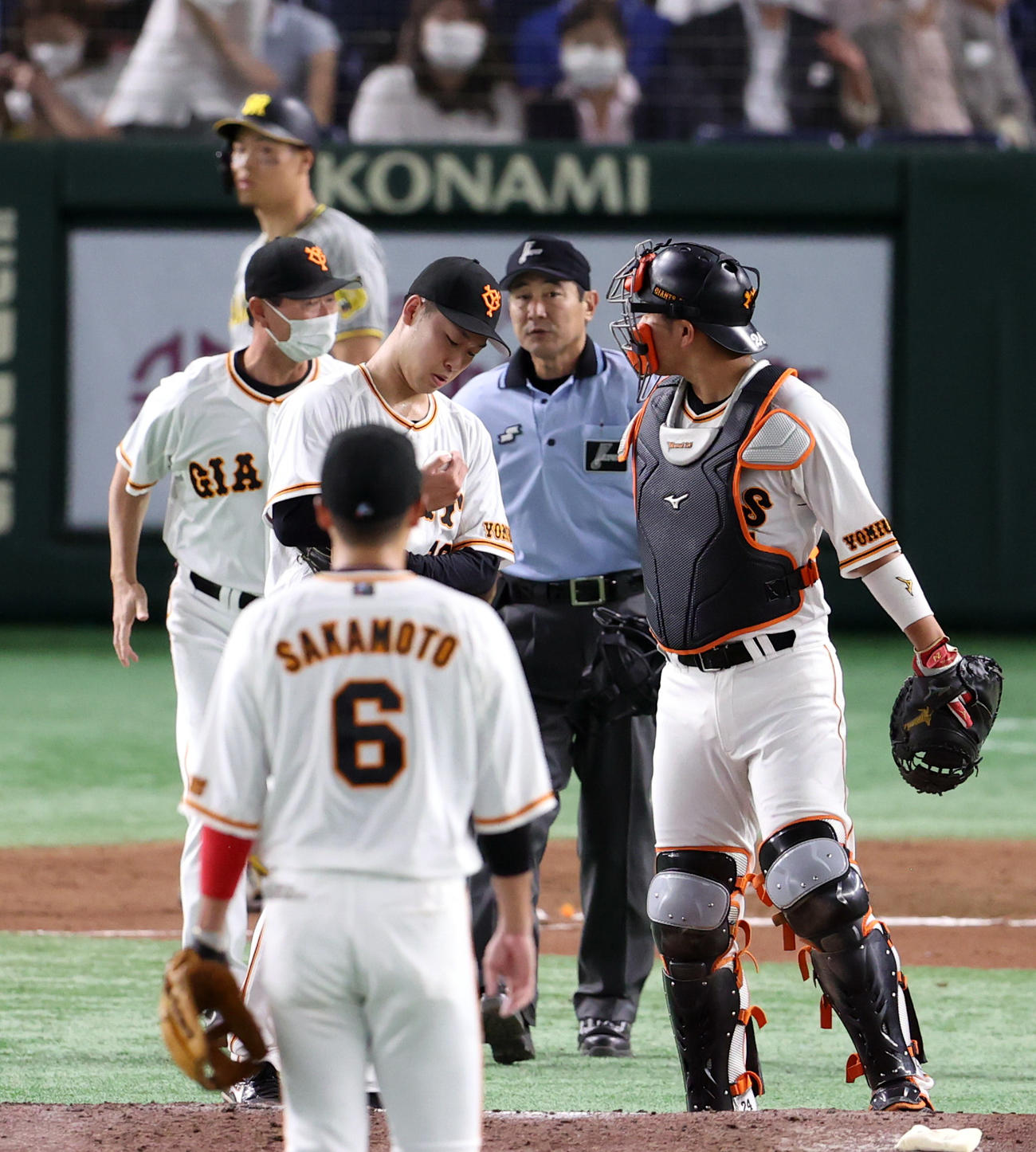 巨人対阪神　7回表阪神無死二塁、打者佐藤輝（後方）に2球投げた後、右手指先の異常で降板する山崎伊（撮影・狩俣裕三）