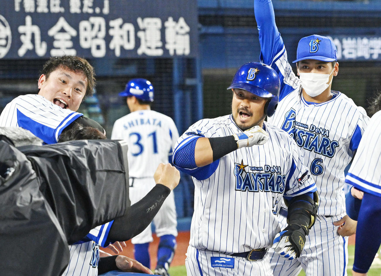 DeNA対広島　1回裏DeNA2死、ソロ本塁打を放った宮崎（右から2人目）は生還しポーズを決める（撮影・滝沢徹郎）