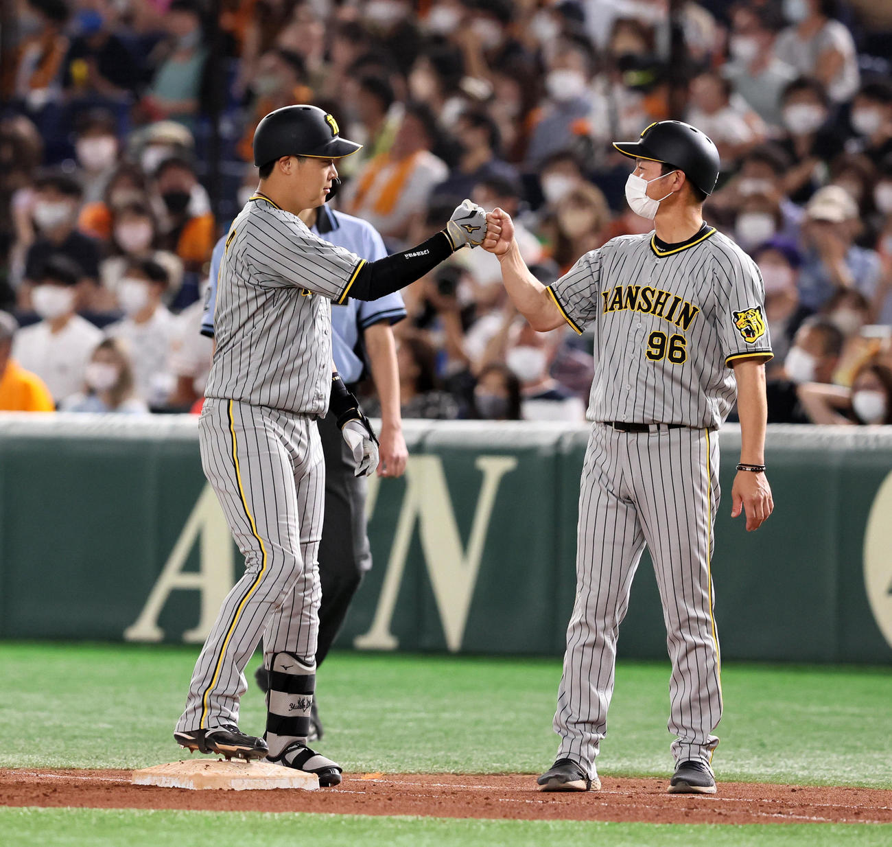 8回表阪神1死満塁、大山は中前適時打を放ち筒井コーチ(右）とタッチ（撮影・加藤哉）