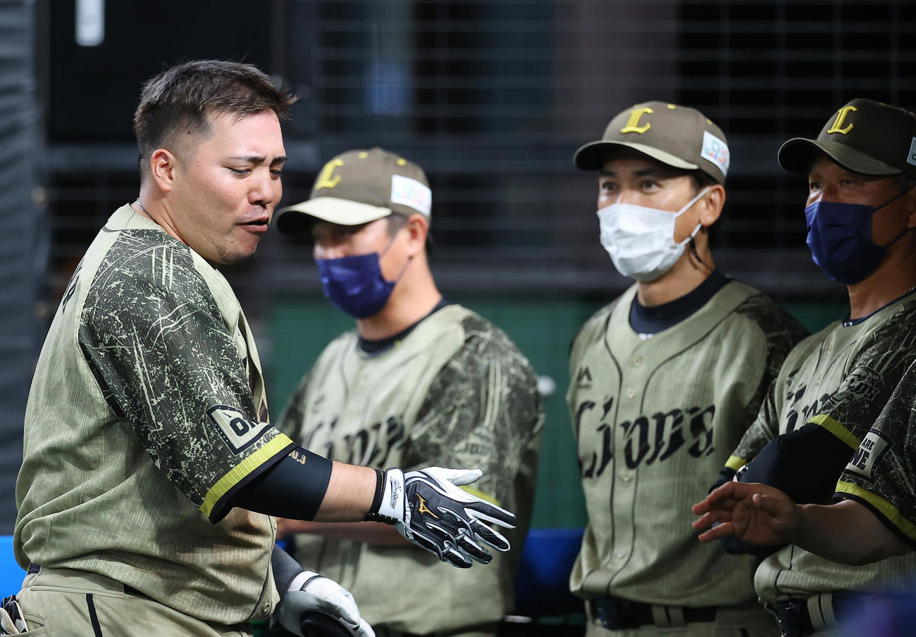 西武対オリックス　8回裏西武1死一、二塁、交代でベンチに下がりナインの出迎えを受ける山川（左）（撮影・垰建太）