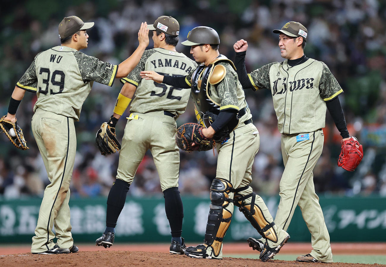 西武対オリックス　オリックスに勝利し最後を締めた西武増田（右）と捕手柘植（同2人目）はナインとタッチを交わす（撮影・垰建太）