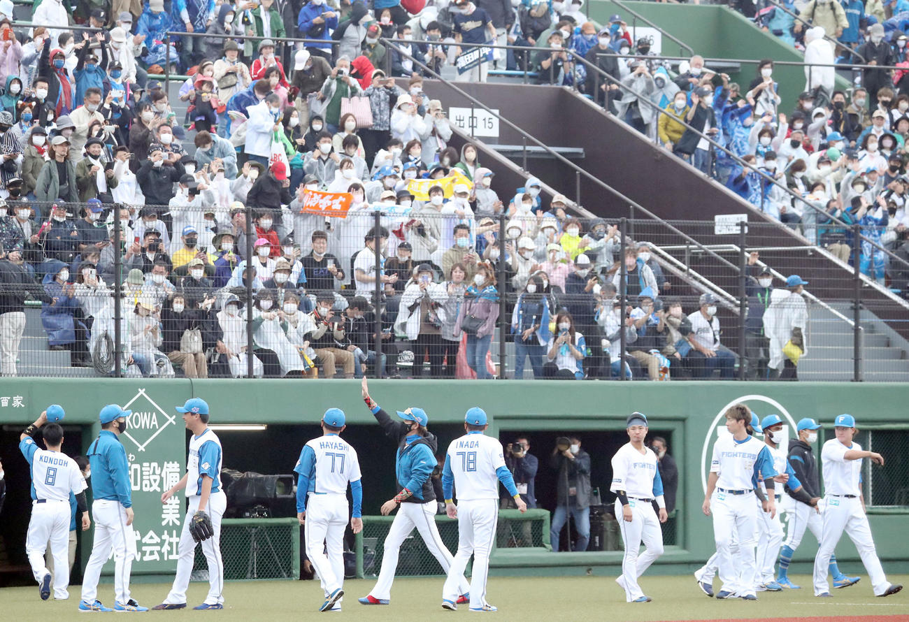 日本ハム対オリックス　7回日没コールドとなりスタンド応援席のファンに手を振りながら引き揚げる新庄監督（中央手前）と選手たち（撮影・佐藤翔太）