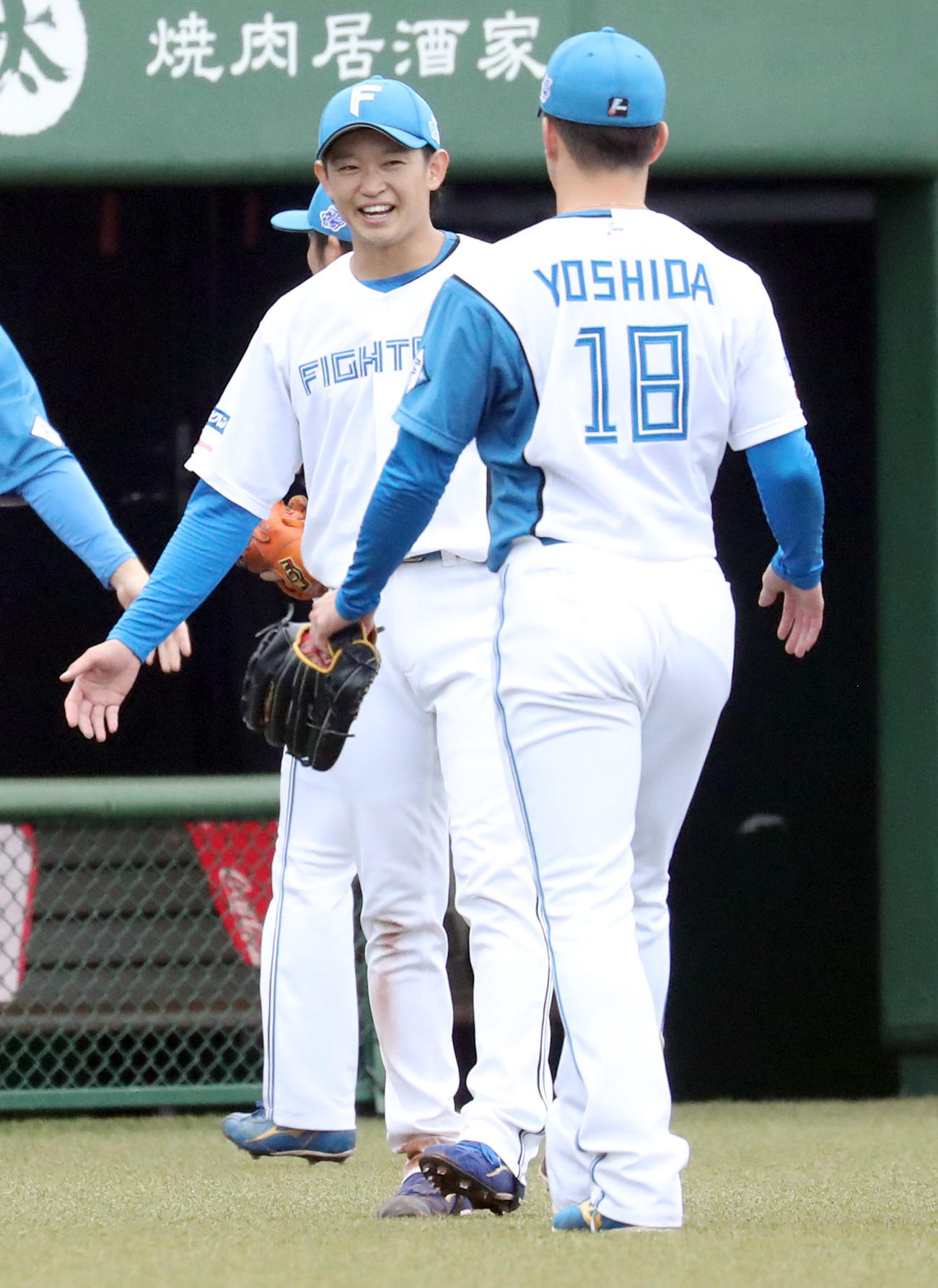 日本ハム対オリックス　鈴木（左後方）は笑顔で吉田を出迎える（撮影・佐藤翔太）