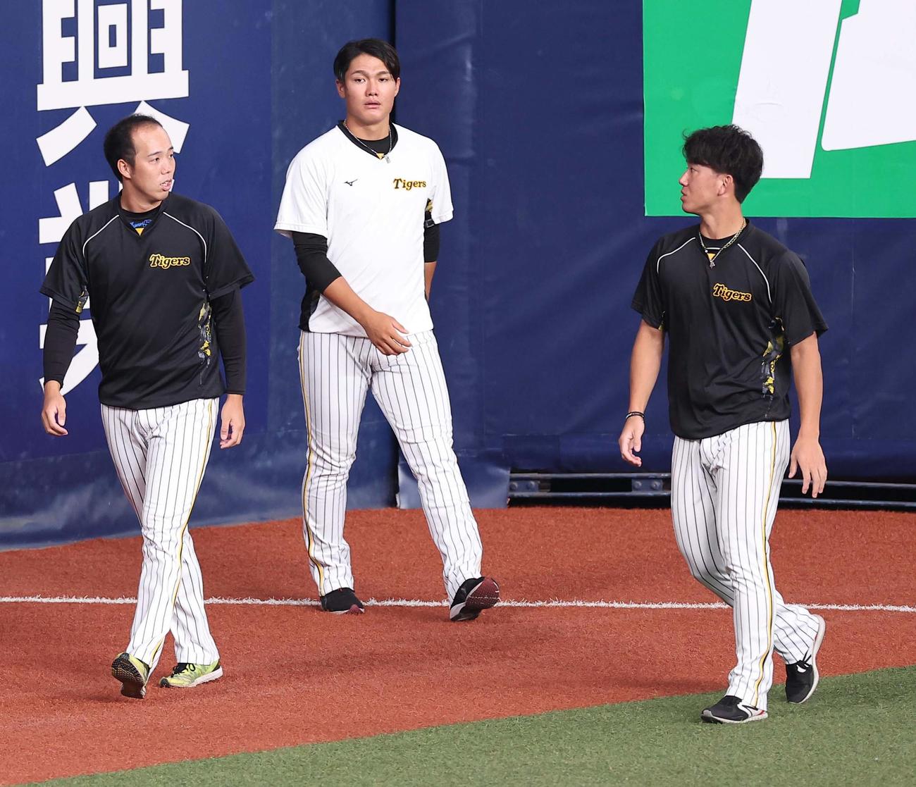 阪神対DeNA　青柳（左）は伊藤将（右）、西純と話しながら外野を歩く（撮影・上田博志）