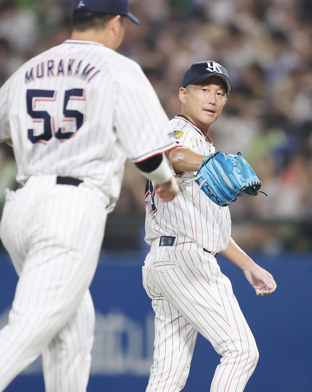 ヤクルト対広島　4回表を終え、村上（左）とタッチを交わすヤクルト先発の石川（撮影・狩俣裕三）