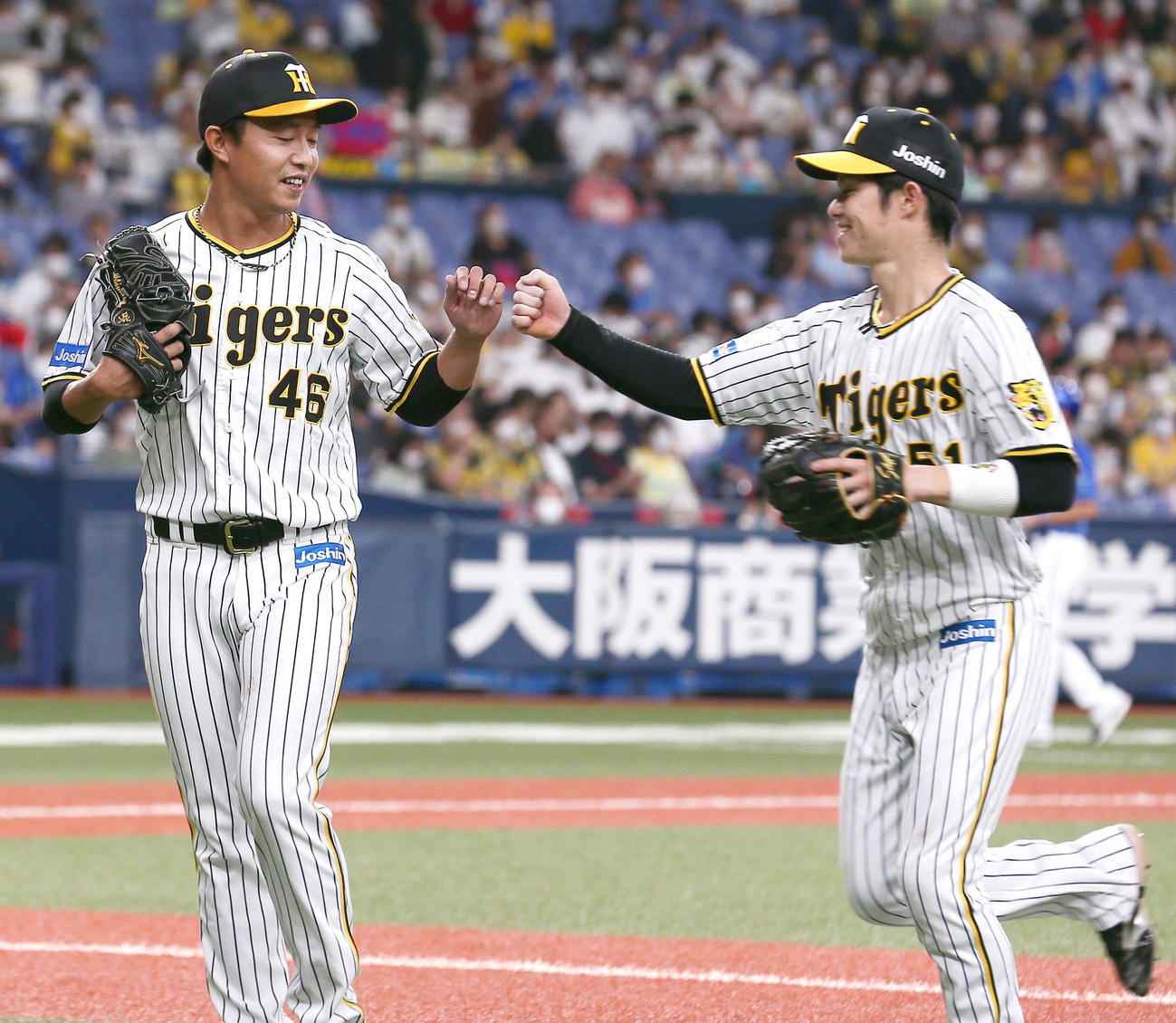 阪神対DeNA 6回、阪神2番手で登板の島本（左）は無失点で終え中野とグータッチでする（撮影・上山淳一）