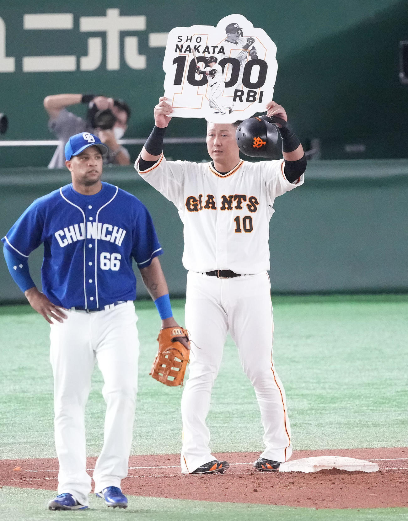 巨人対中日　5回裏巨人2死一、二塁、左前適時打を放ち、通算1000打点の中田はパネルを掲げる。一塁手ビシエド（撮影・鈴木みどり）