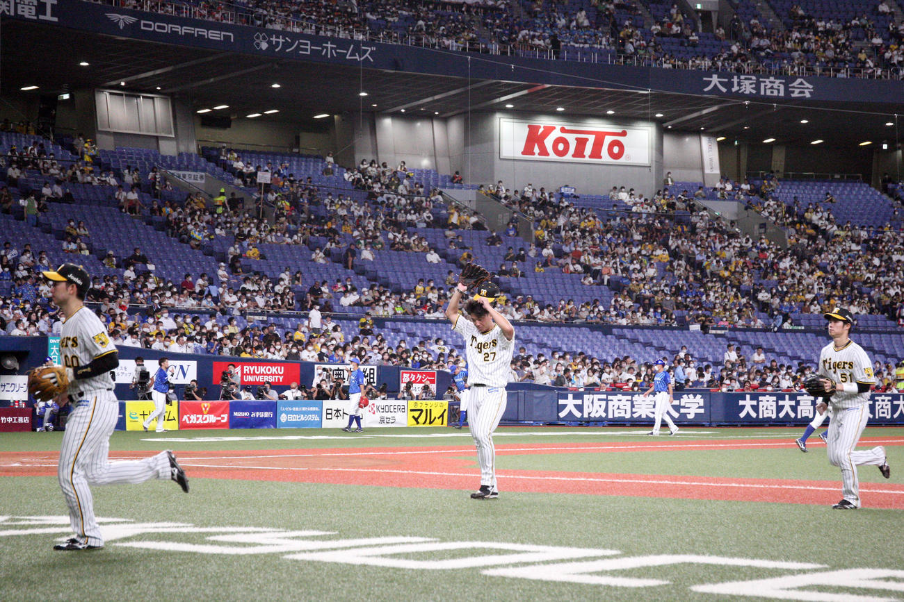 阪神対DeNA 7回、DeNA桑原に満塁本塁打を被弾した阪神伊藤将（中央）は汗を拭きながらベンチへ引き揚げる（撮影・上山淳一）