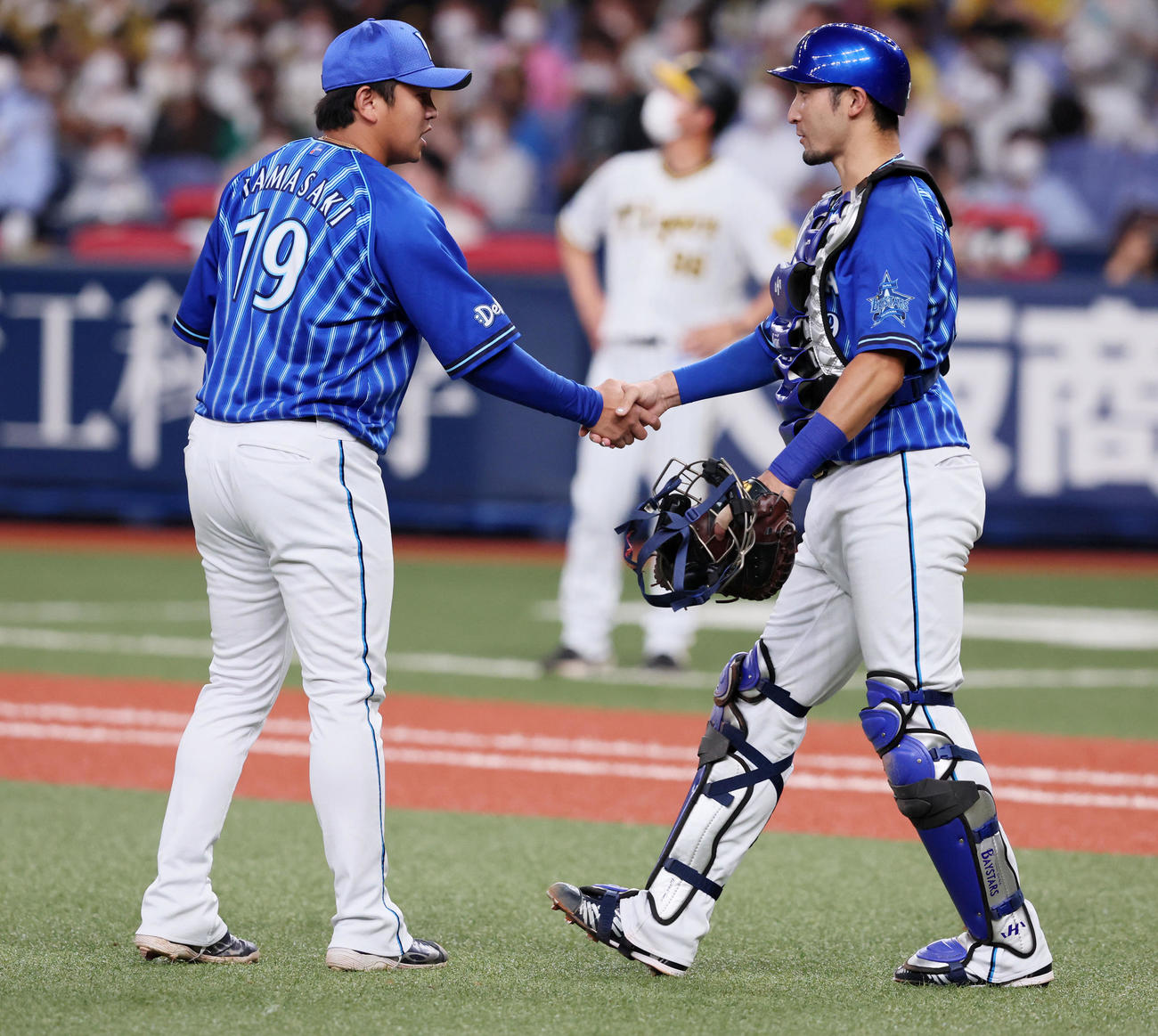 阪神対DeNA 9回裏阪神2死一、二塁、山崎は糸原を中飛に仕留め通算200セーブを達成し伊藤（右）と握手する（撮影・加藤哉）