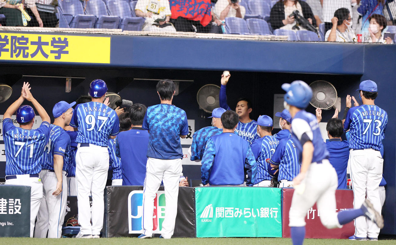 阪神対DeNA　通算200セーブを達成したDeNA山崎はベンチでナインらから祝福され記念球を掲げる（撮影・上山淳一）