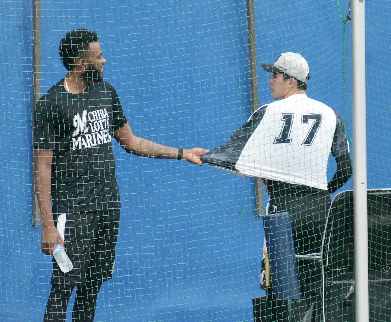 ロッテ対西武　試合前の練習でゲレーロ（左）に上着を引っ張られるロッテ佐々木朗（撮影・小沢裕）