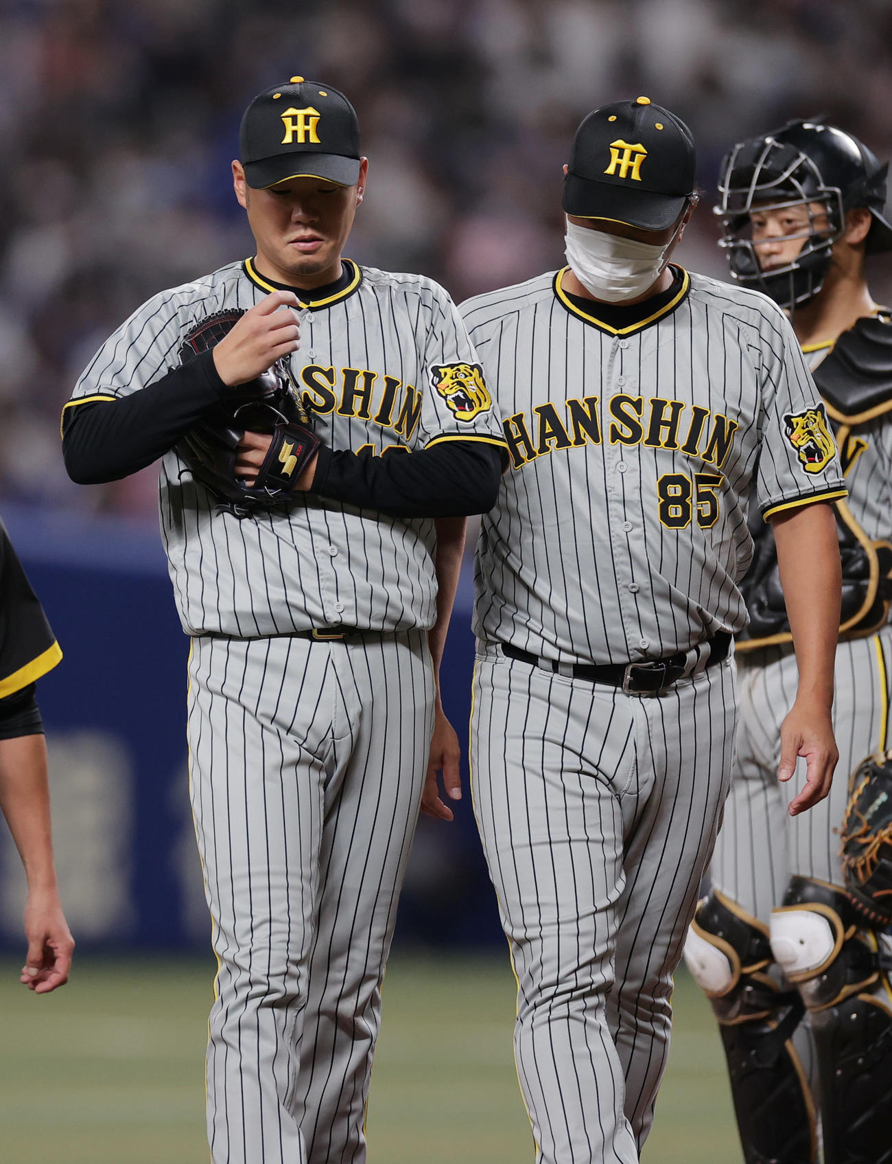 中日対阪神　4回裏の投球前、指を気にしながらベンチへ下がる阪神西勇（左）。中央は福原コーチ（撮影・前田充）