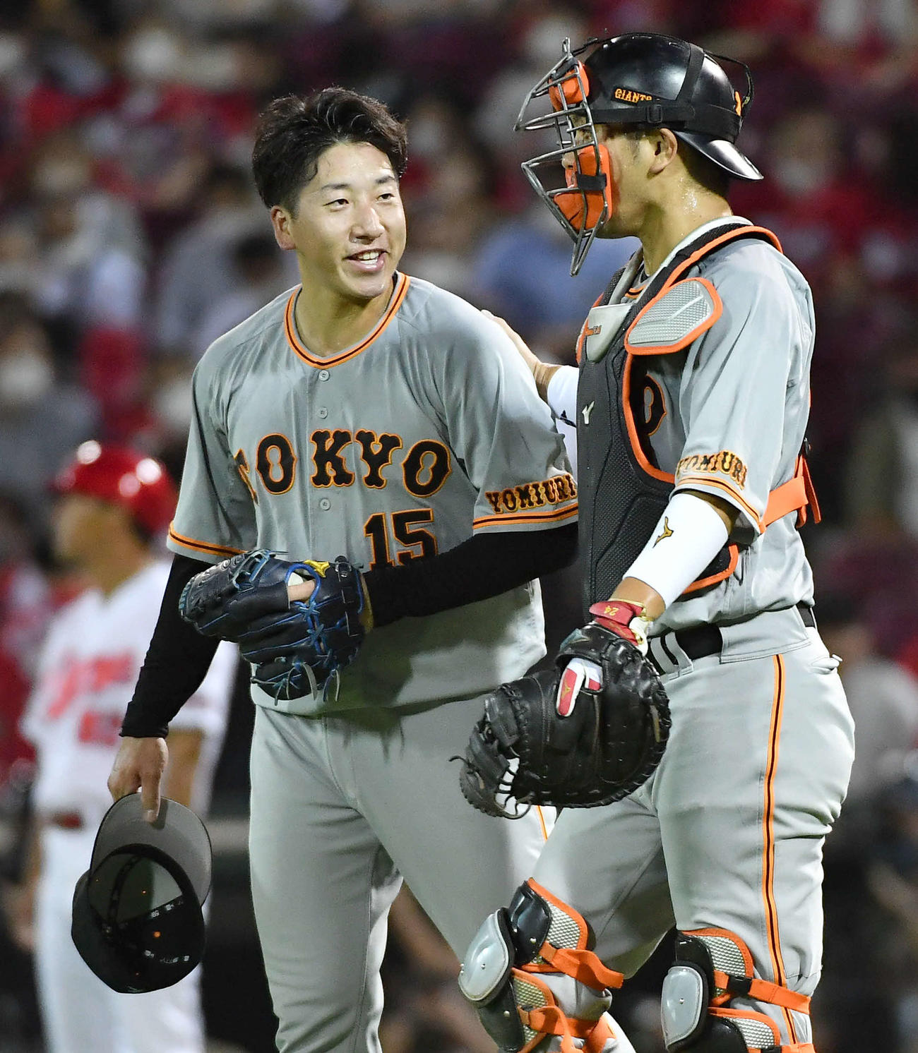 広島対巨人　最終回を締めて30セーブに到達し、大城（右）から肩をたたかれ笑顔を見せる大勢（撮影・岩下翔太）