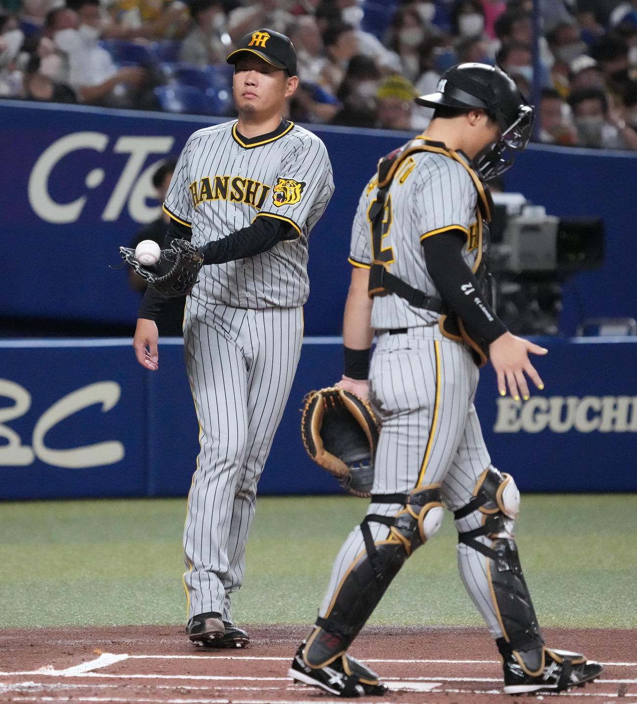 中日対阪神　1回裏中日無死一、三塁、ピンチを背負い球審からボールを受け取る阪神先発の西勇（左）（撮影・森本幸一）