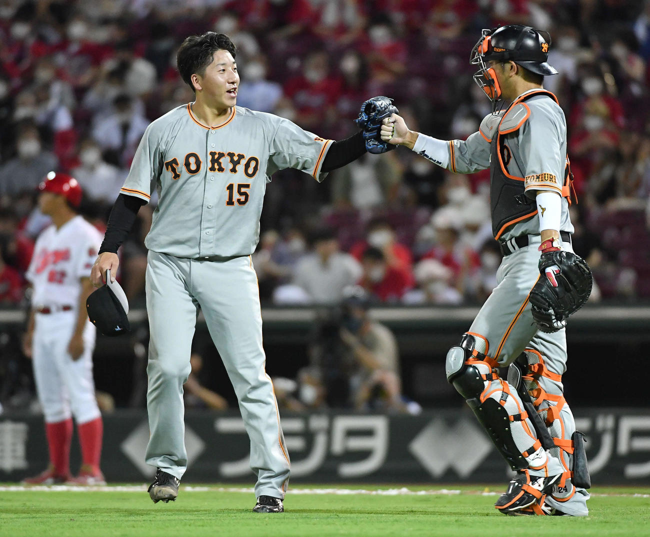 広島対巨人　30セーブ目を挙げた大勢（左）は、大城とタッチを交わす（撮影・岩下翔太）