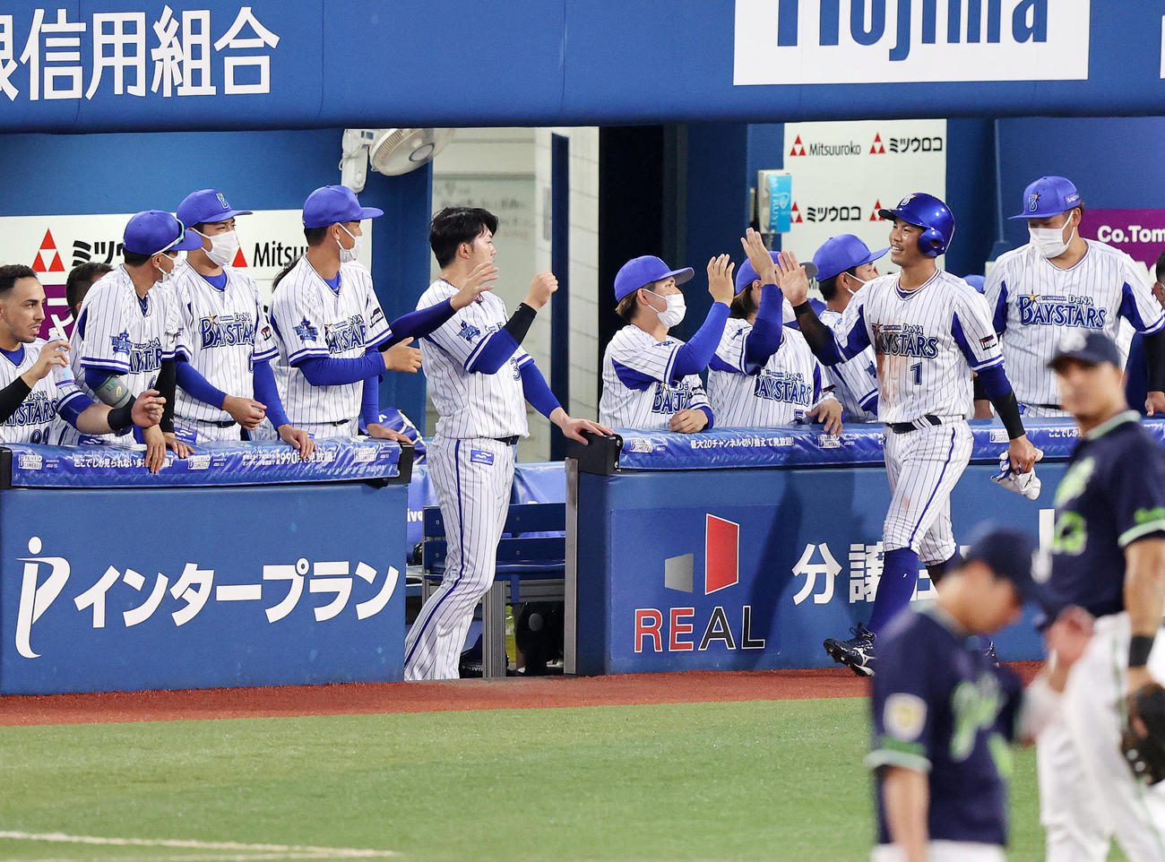 DeNA対ヤクルト　1回裏DeNA1死二塁、佐野の中前適時打で桑原（右）が生還しベンチ前でタッチ（撮影・鈴木正人）