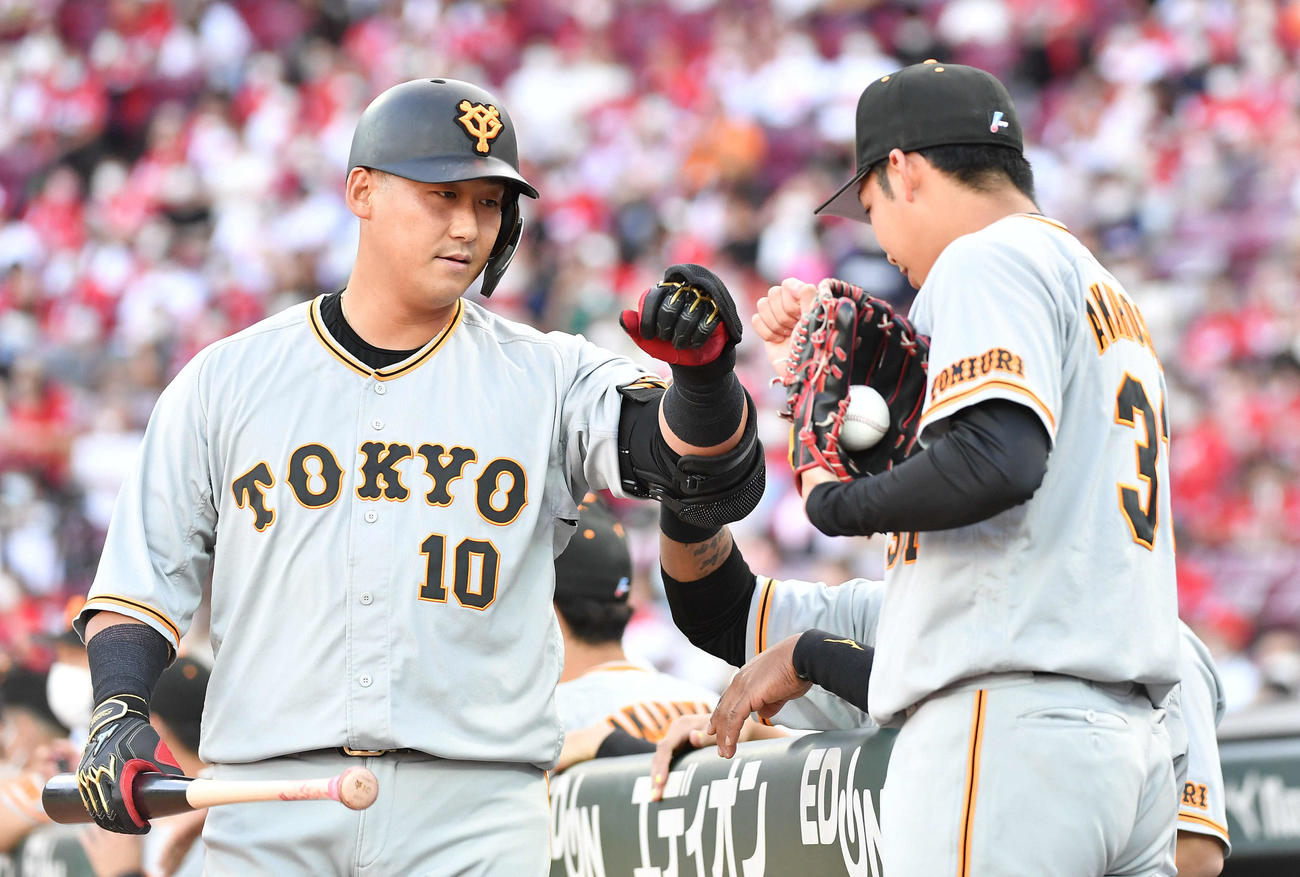 広島対巨人　1回表巨人1死一、三塁、先制の中犠飛を放ち、赤星（右）とタッチを交わす中田（撮影・岩下翔太）