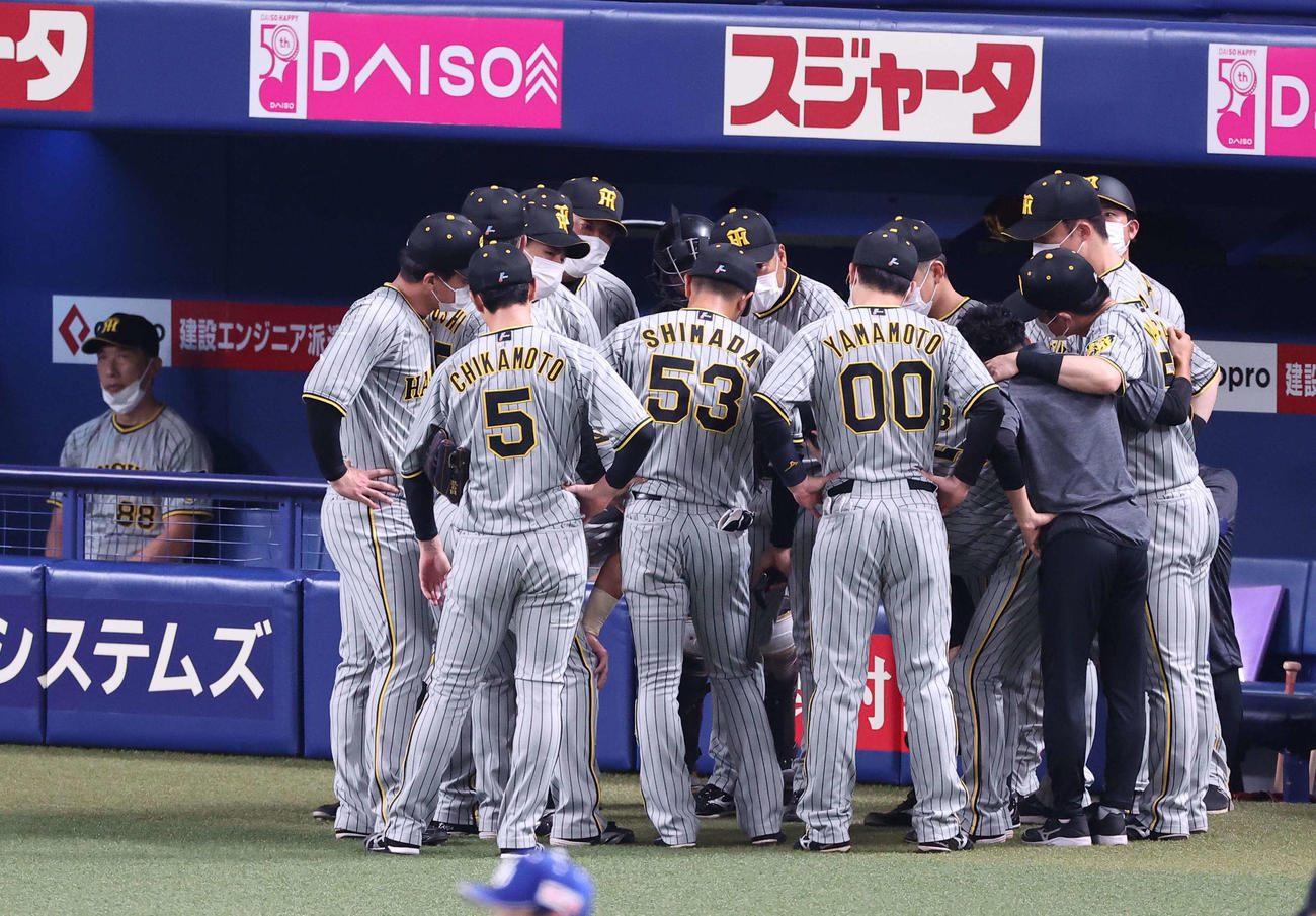 中日対阪神　4回、ベンチ前で円陣を組む阪神ナイン。左は矢野監督（撮影・上田博志）