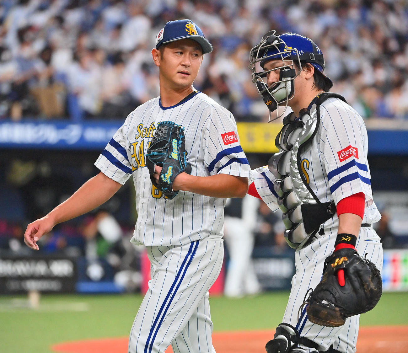 5回を投げきり甲斐（右）とタッチを交わすソフトバンク先発の奥村（撮影・和賀正仁）